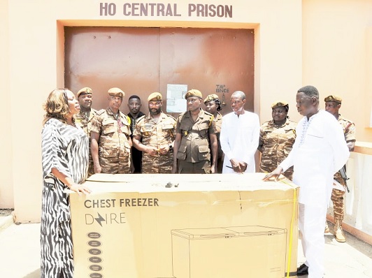 Angela Oforiwaa Alorwu-Tay (left), MP for Afadzato South, presenting the deep freezer to Martin Darku (right), Deputy Director of Prisons, while some prison officers look on